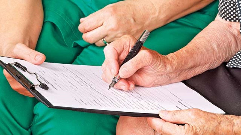 Insurance claim form put on patient's hand in hospital with pen, prepare for patient write claim insurance.