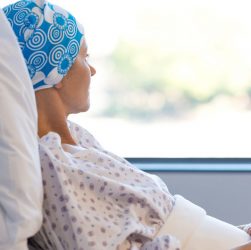 Depressed Cancer Patient Lying in Hospital Bed and Looking Outside The Window.