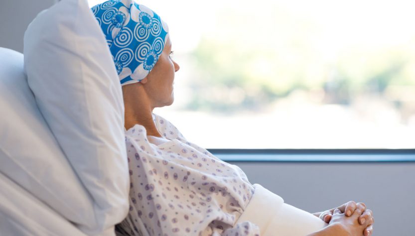 Depressed Cancer Patient Lying in Hospital Bed and Looking Outside The Window.